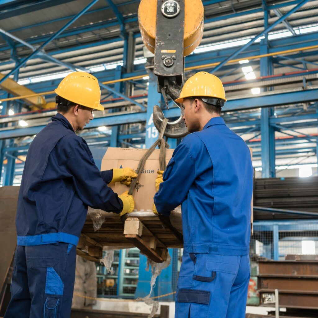 Custom Compression Springs 23 Workers operating a hoist in an industrial plant, an application for compression coil springs (Zigoal)